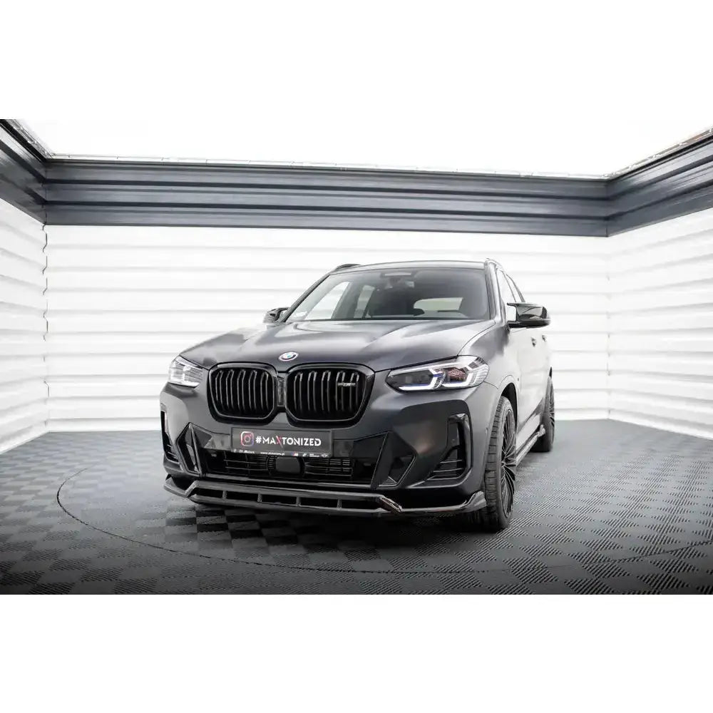 Front lip på sort BMW X3 G01 Facelift M-Pack med matt finish og svarte felger i lyst rom.