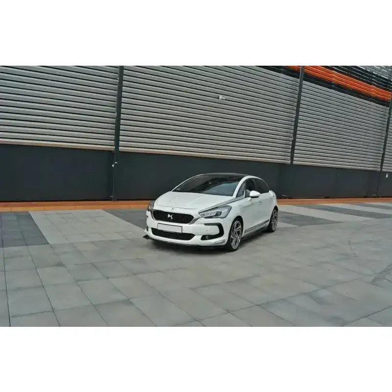 Front splitter på hvit Citroen Ds5 Facelift med svarte detaljer parkert foran industribygning.