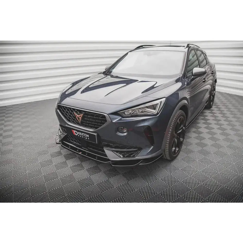 Frontspoiler på mørkblå Cupra Formentor med sorte detaljer og sportslige felger, fotografert innendørs.
