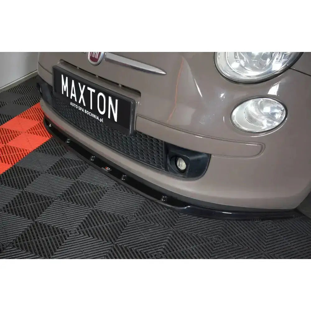 Frontsplitter på beige Fiat 500 Hatchback Preface, nærbilde fra skrå vinkel, sort frontleppe mot rutegulv.