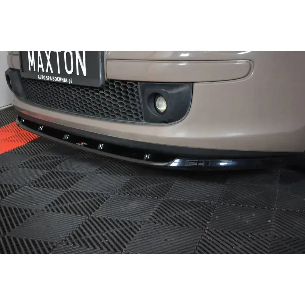 Front lip på sort frontsplitter i blank plast montert under støtfanger på beige Fiat 500, lav vinkel.
