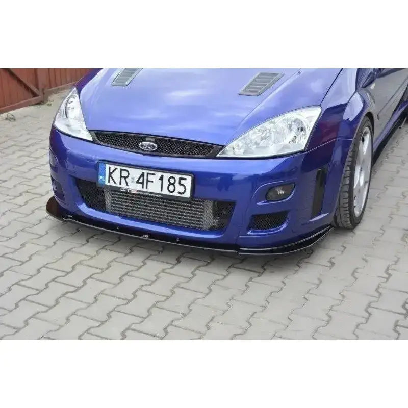 Frontspoiler på blå Ford Focus Mk1 RS med svart frontsplitter og luftinntak, sett fra lav vinkel.