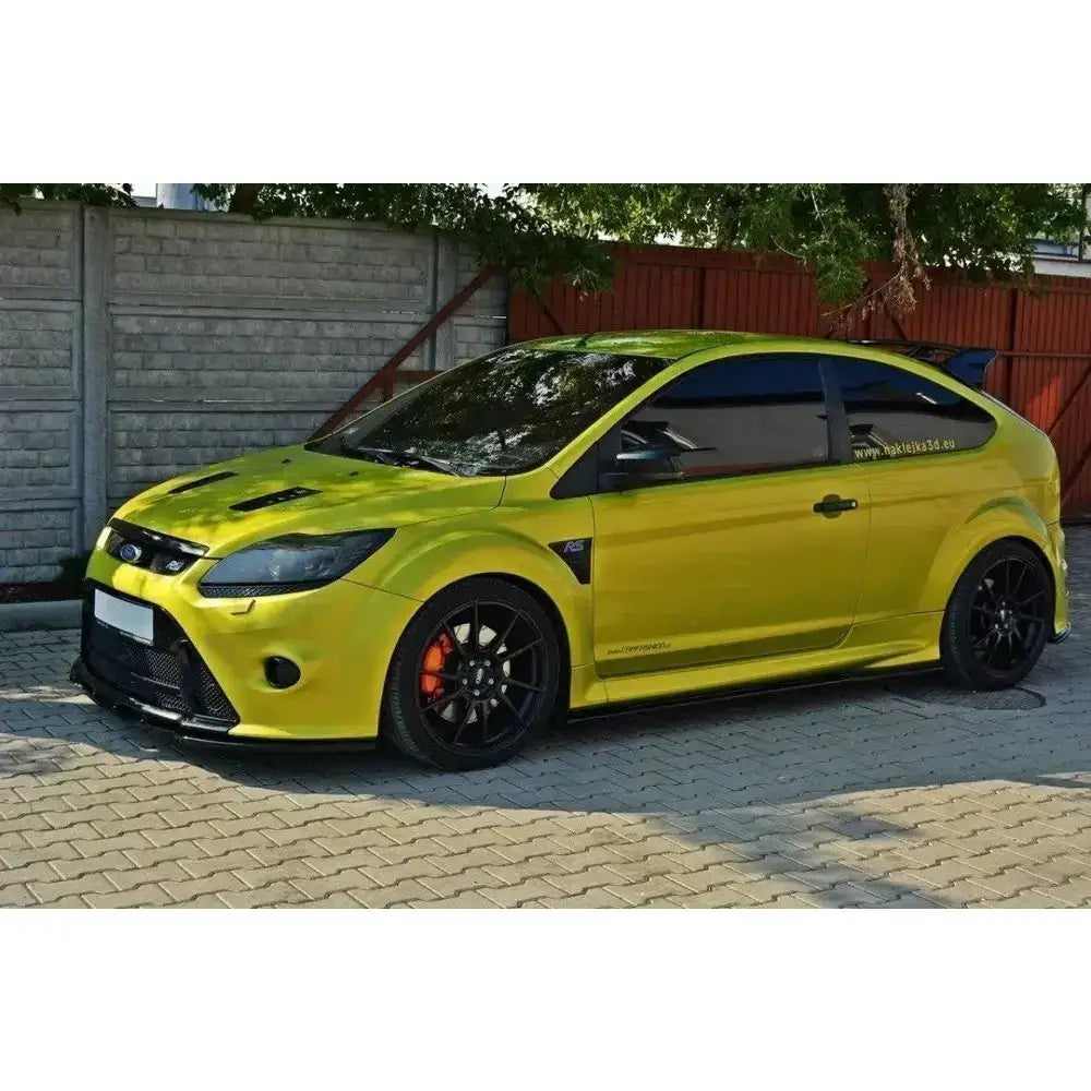 Frontspoiler på gulgrønn Ford Focus Mk2 RS med sorte felger og stor hekkspoiler, sett fra siden.