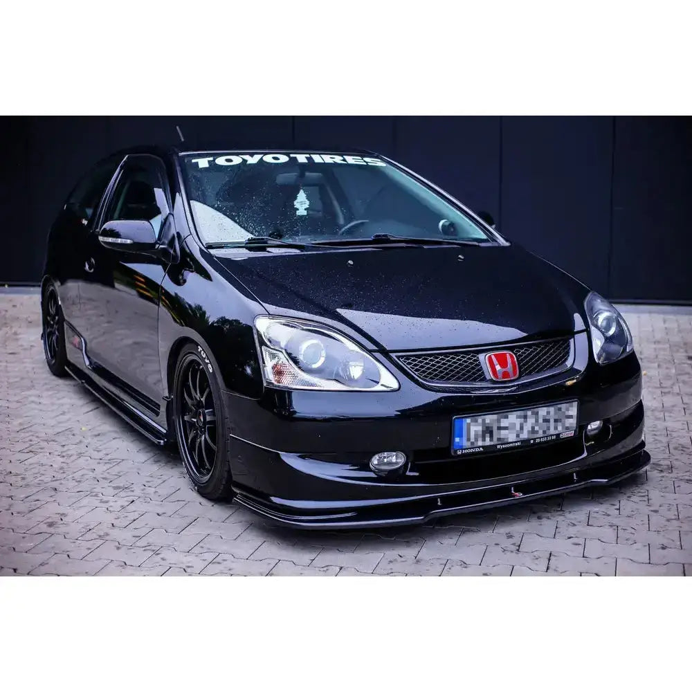 Front lip på Honda Civic Ep3 Type-R Facelift med svarte felger og røde detaljer, sett skrått forfra.