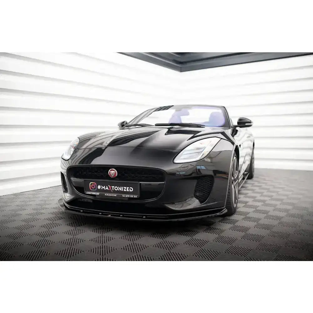 Frontsplitter på Jaguar F-Type Mk1 Facelift, sort sportsbil sett skrått forfra innendørs.