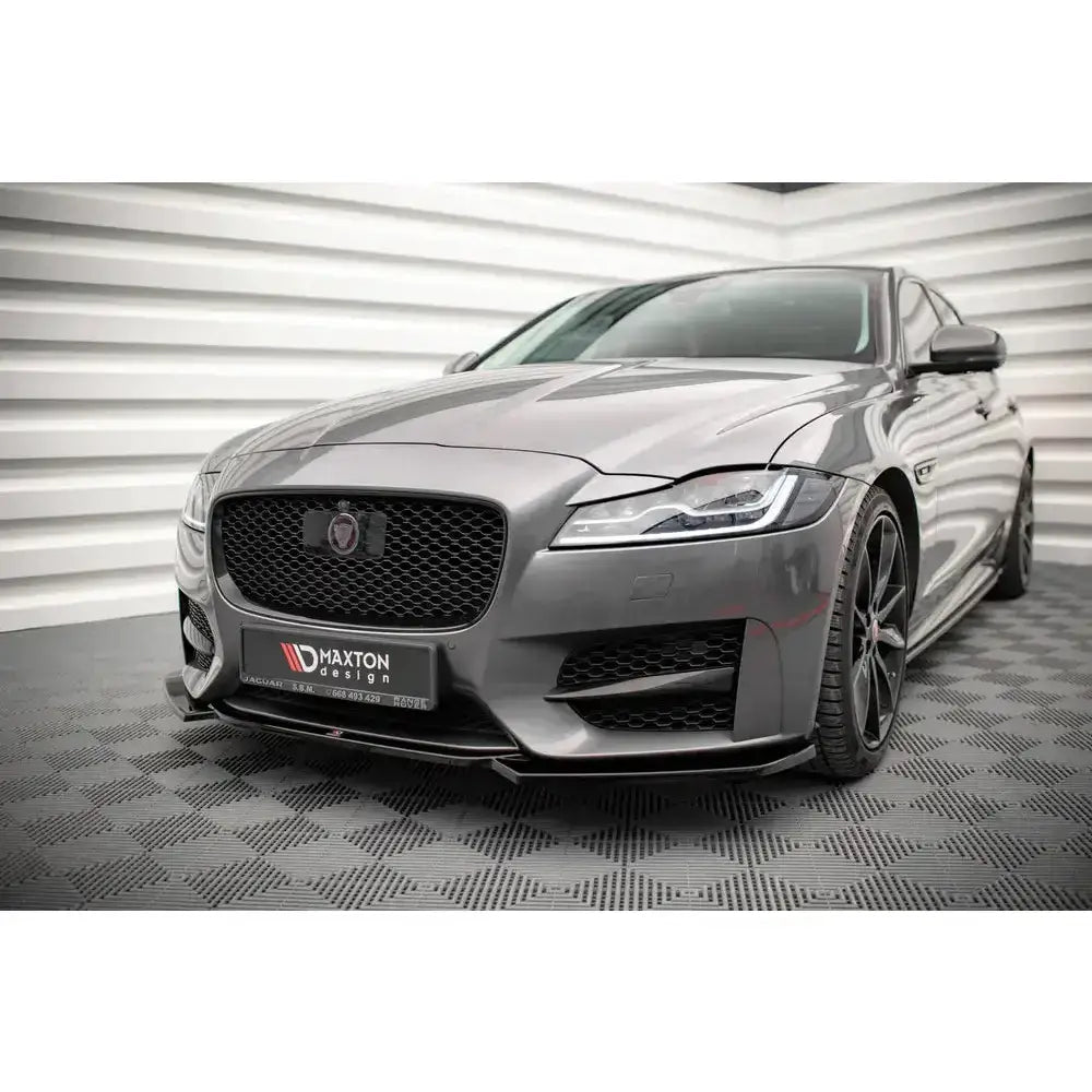 Frontsplitter på Jaguar XF R-Sport Mk2 med sporty design, svart grill og markante felger innendørs.