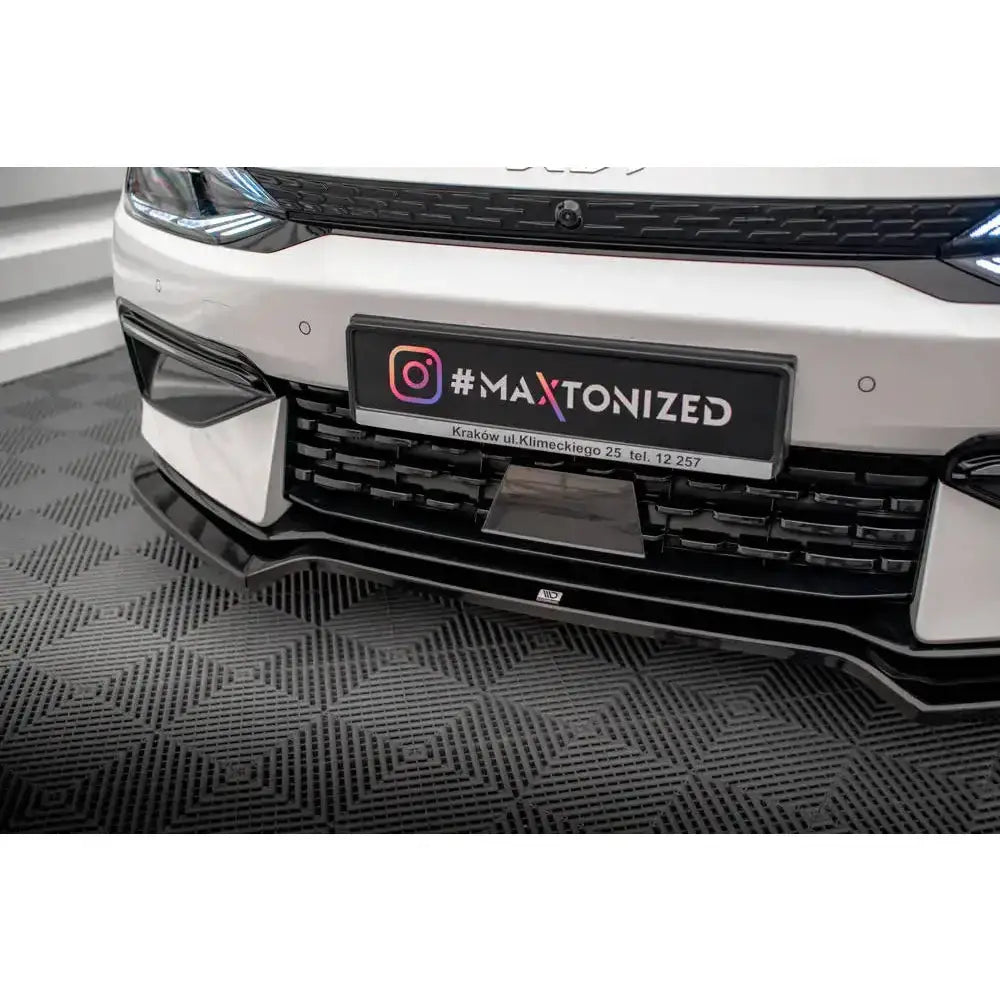 Frontsplitter til Kia EV6 GT-Line Mk1, svart plast montert foran, sett nedenfra med grill og skiltbrakett.