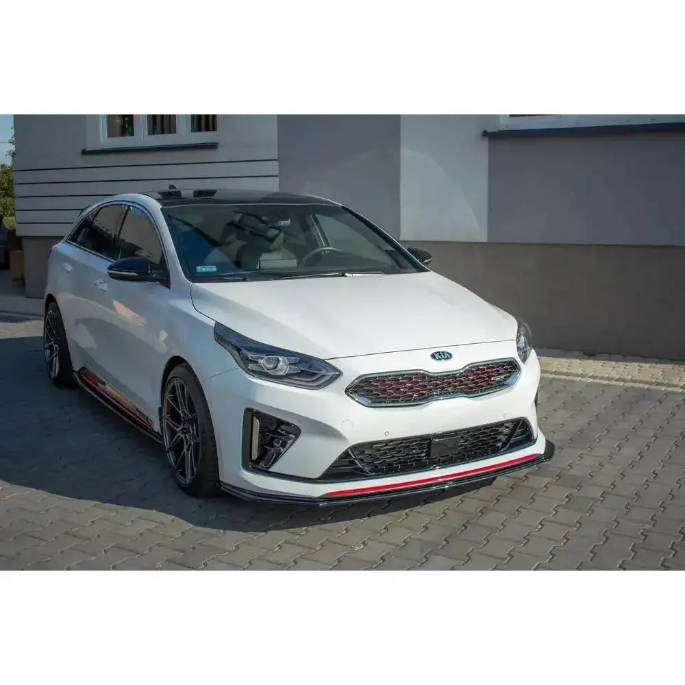 Frontspoiler på hvit Kia Proceed GT Mk 3 med sorte og røde detaljer, parkert på brostein.