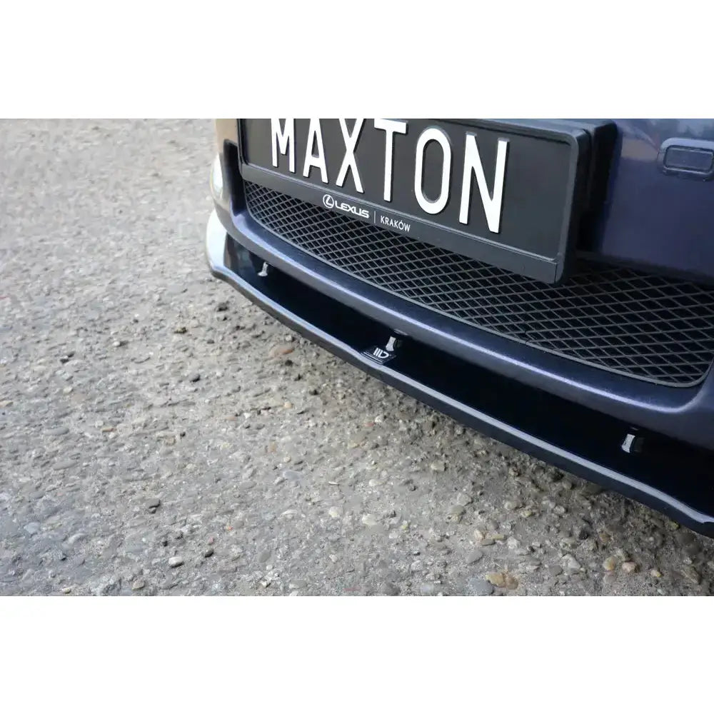 Front lip på Lexus Gs Mk.3, sort glanset frontspoiler sett nedenfra med monteringspunkter og diskret logo.