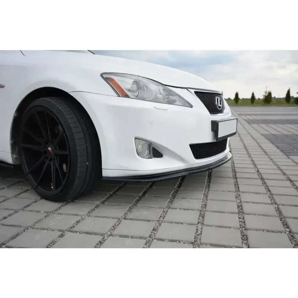 Front lip på Lexus IS Mk2 med hvit lakk, sort felg og lav frontspoiler parkert på brostein.