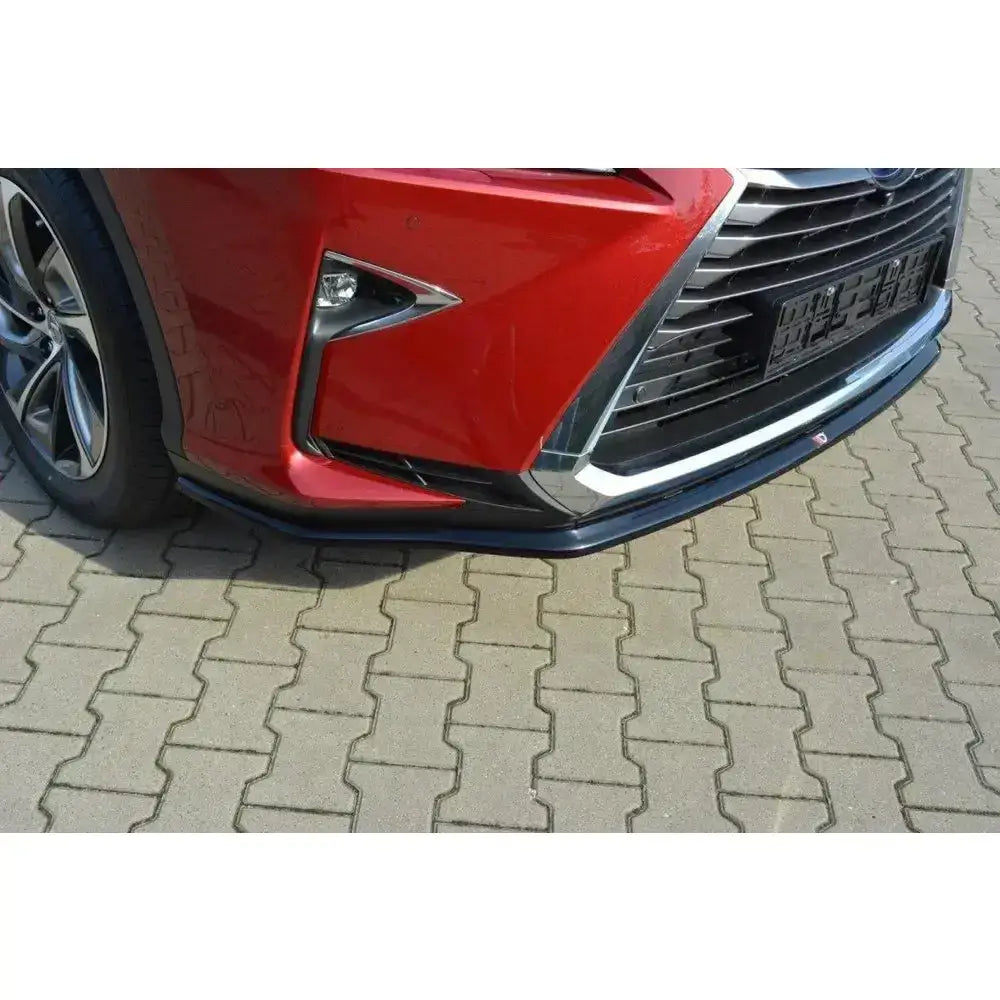 Front lip på Lexus Rx Mk4, nærbilde av rød frontfanger med svart og sølv spoiler på belegningsstein.