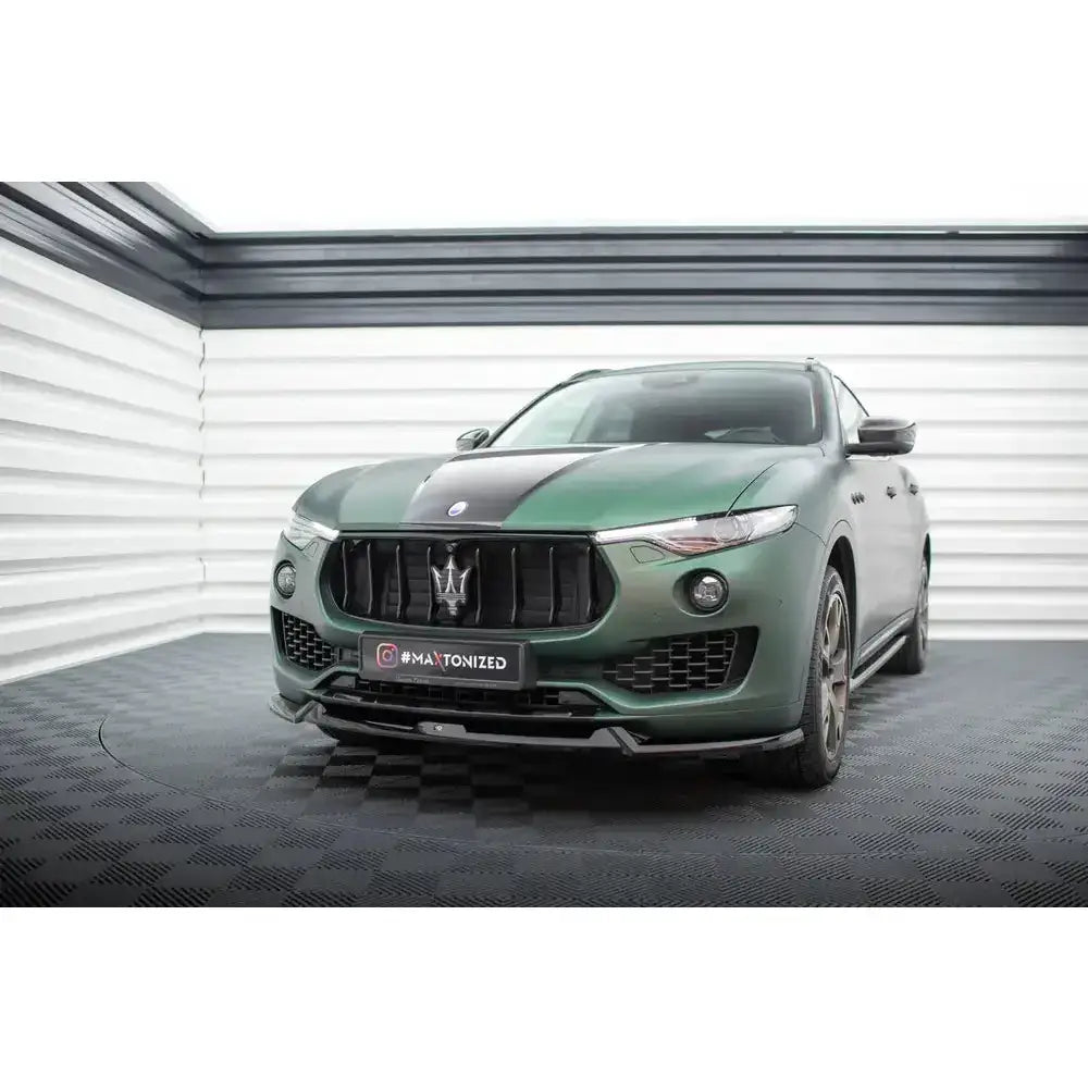 Front lip på grønn Maserati Levante Mk1 med sort panserstripe og markant grill, sett skrått forfra.