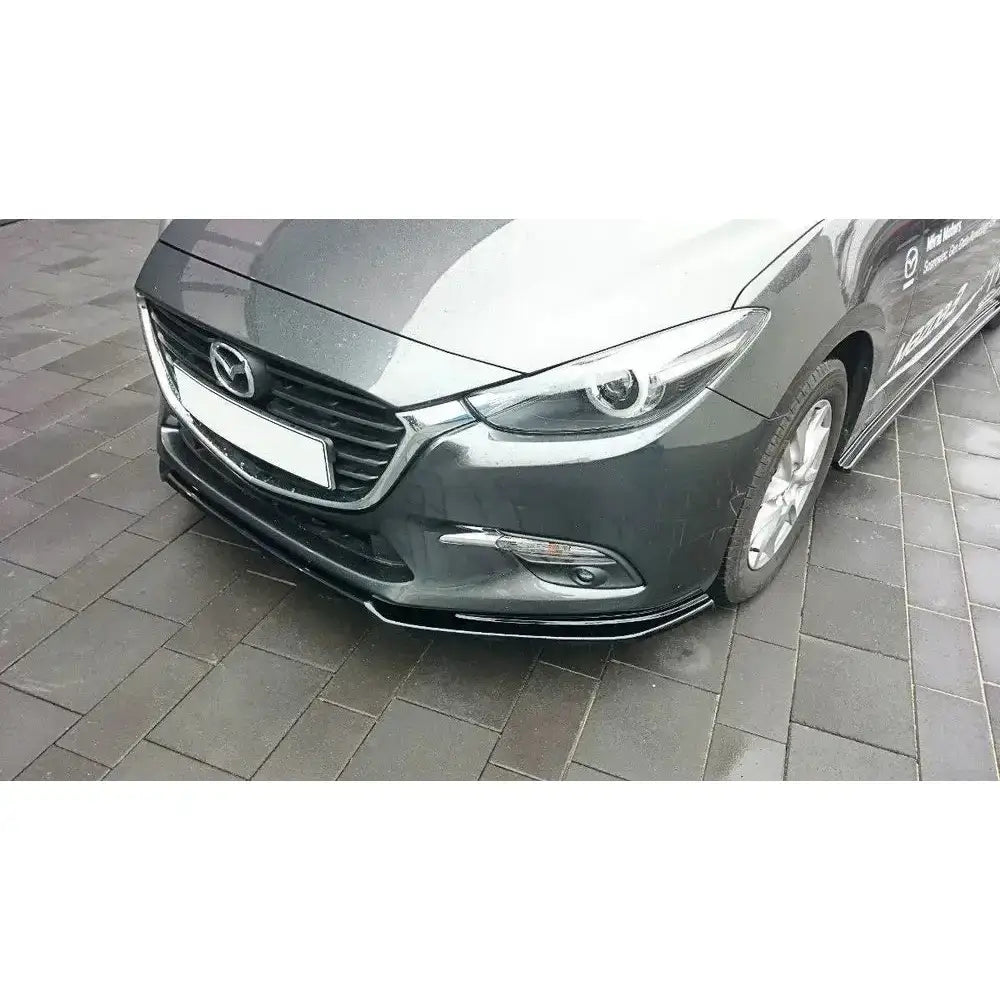 Frontspoiler på Mazda 3 BM Facelift, viser grå bil skrått forfra med grill, lykter og felg synlig.