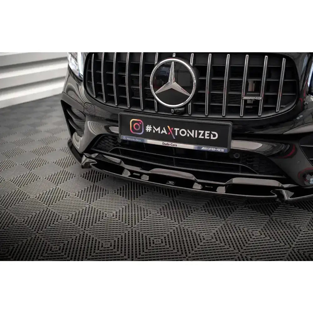 Frontsplitter på Mercedes-AMG GLB 35 X247 med blank sort spoiler og AMG-grill i nærbilde.