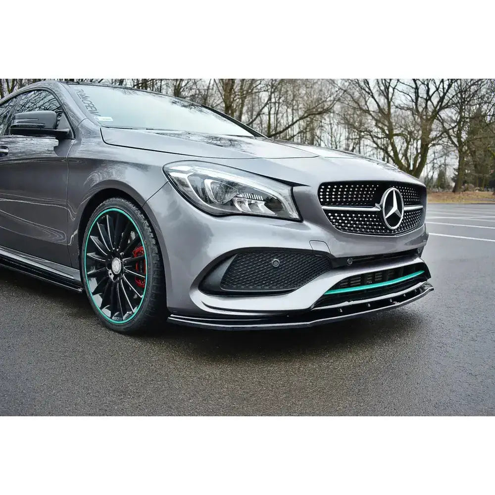Frontsplitter på grå Mercedes Benz Cla C117 Amg-Line med sorte felger og turkise detaljer på våt asfalt.