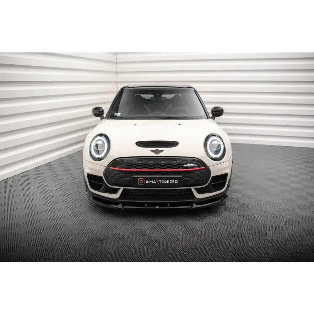 Frontspoiler på hvit Mini Cooper Clubman JCW F54 Facelift med sorte og røde detaljer, sett forfra.