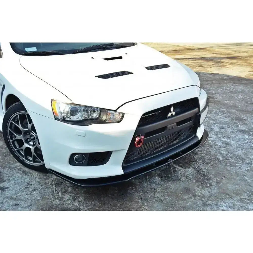 Frontsplitter på Mitsubishi Lancer Evo X, sort utførelse med rød slepekrok og sportsfelg, sett fra siden.