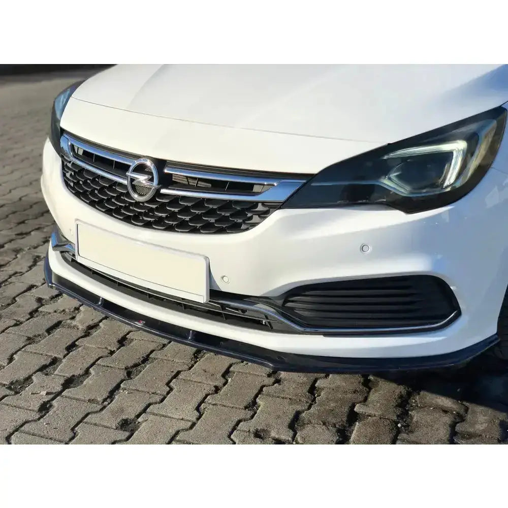 Frontleppe V.1 Opel Astra K Opc-Line montert på hvit bil med svart spoiler og kromdetaljer på grillen.