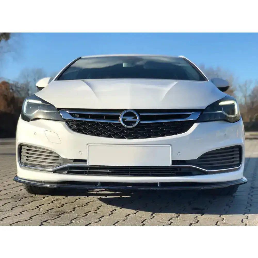 Front lip på hvit Opel Astra K Opc-Line med svart grill, kromdetaljer og blank frontspoiler.