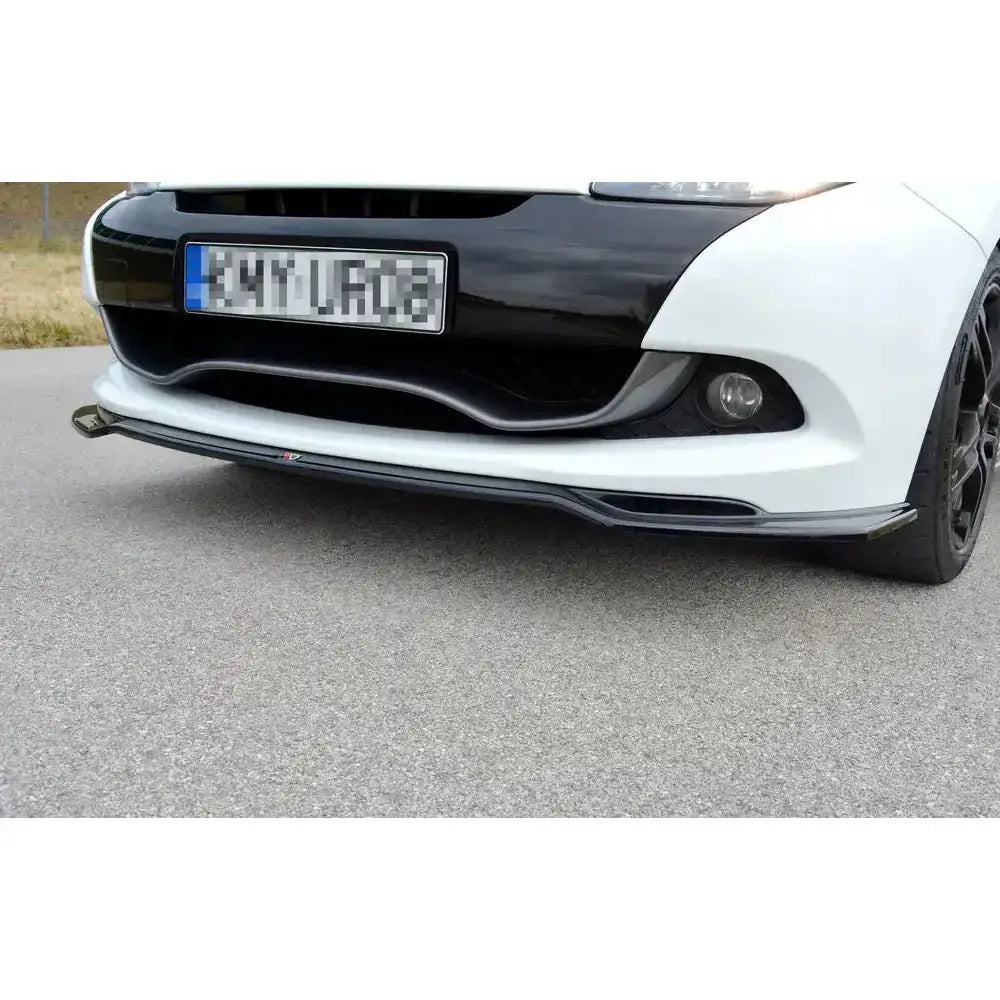 Frontsplitter til Renault Clio Mk3 Rs Facelift i sort plast med detaljstripe, montert under hvit støtfanger.