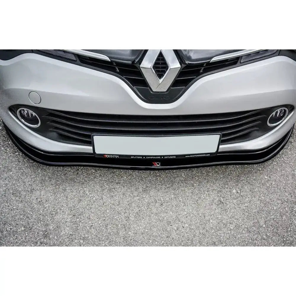 Frontsplitter til Renault Clio Mk4 i sort plast, montert på sølvfarget bil, sett ovenfra på asfalt.