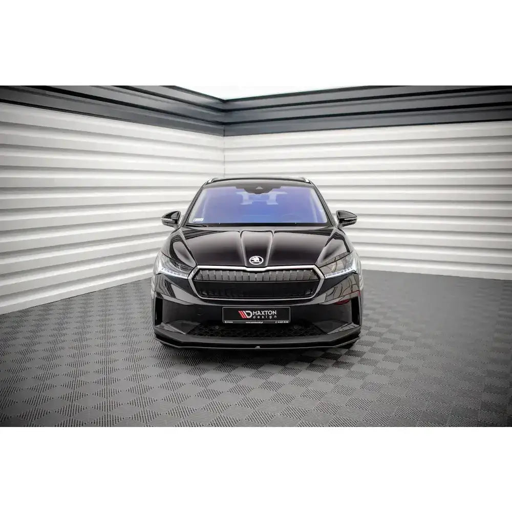 Frontspoiler på Skoda Enyaq iV V.1 sett forfra i lyst industrilokale med rutet gulv.