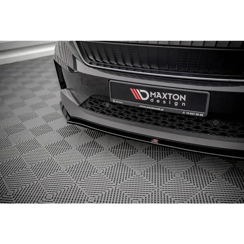 Frontsplitter til Skoda Enyaq iV V.1 i sort blank plast montert foran på bilfanger, nærbilde.
