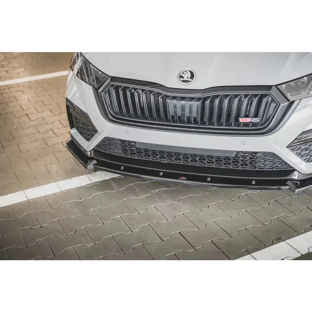 Frontsplitter på Skoda Octavia RS Mk4 V.1 montert under sort grill, sett forfra på hvit bil.