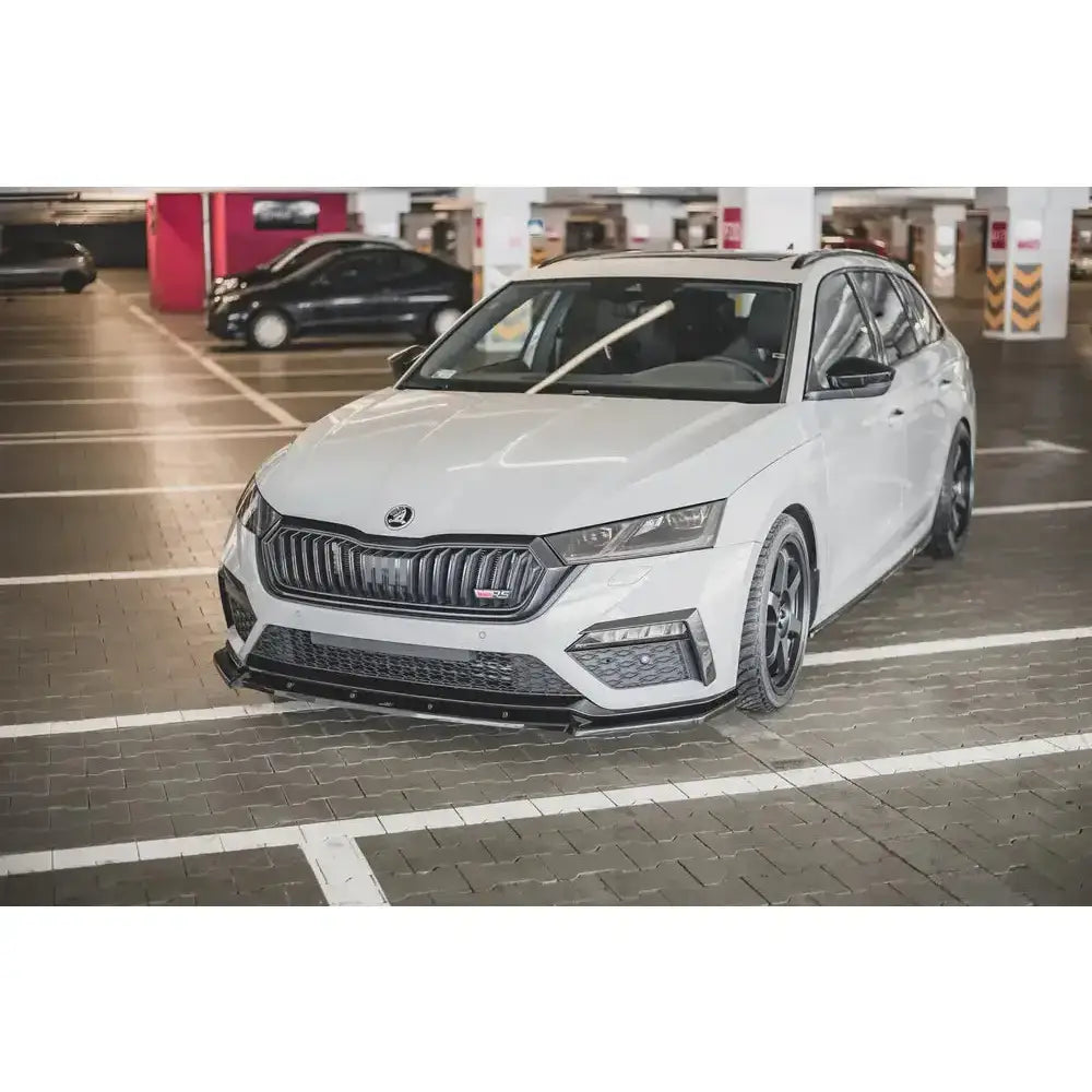 Front splitter på Skoda Octavia RS Mk4 hvit stasjonsvogn sett skrått forfra i parkeringsgarasje.