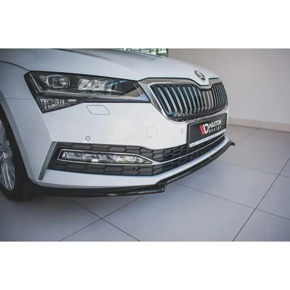 Frontsplitter på Skoda Superb Mk3 FL med svart plastspoiler, sølvgrill og integrerte lykter.
