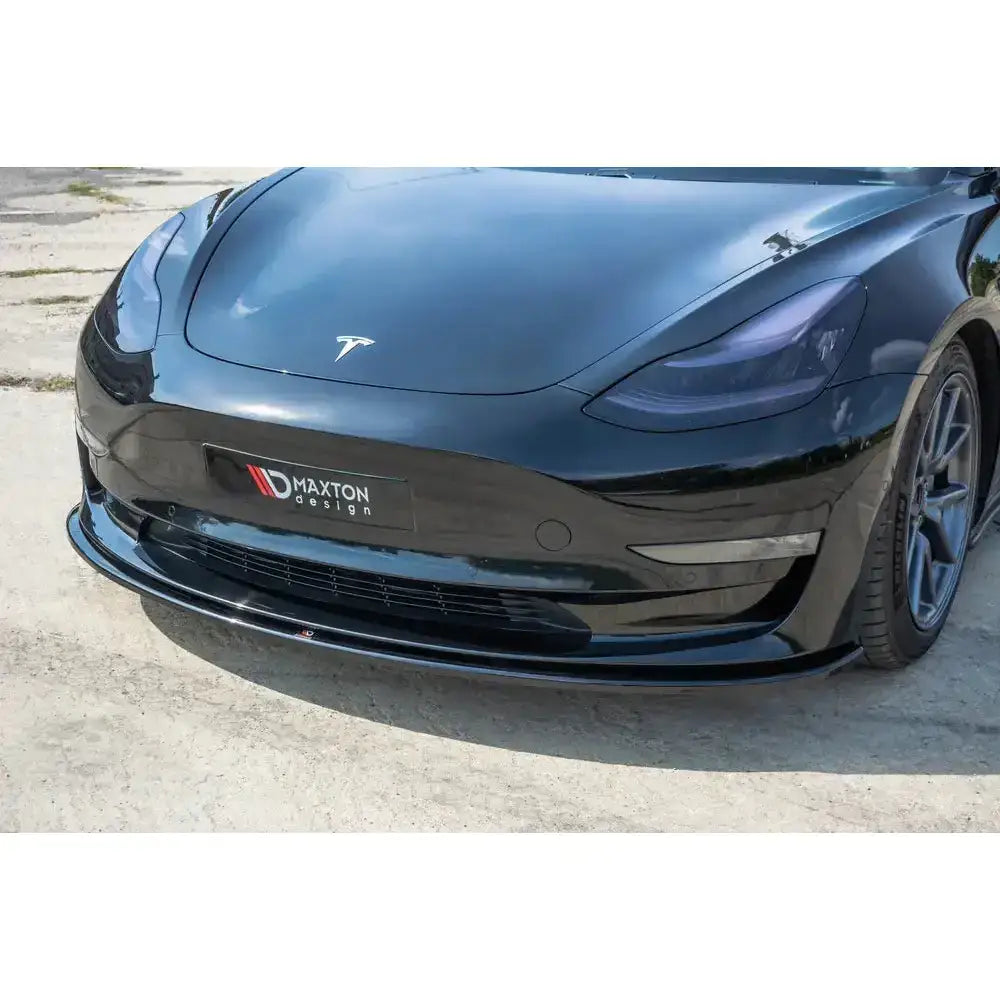 Front lip til Tesla Model 3 V.1 montert på sort bil med blank frontsplitter og Maxton Design-logo.