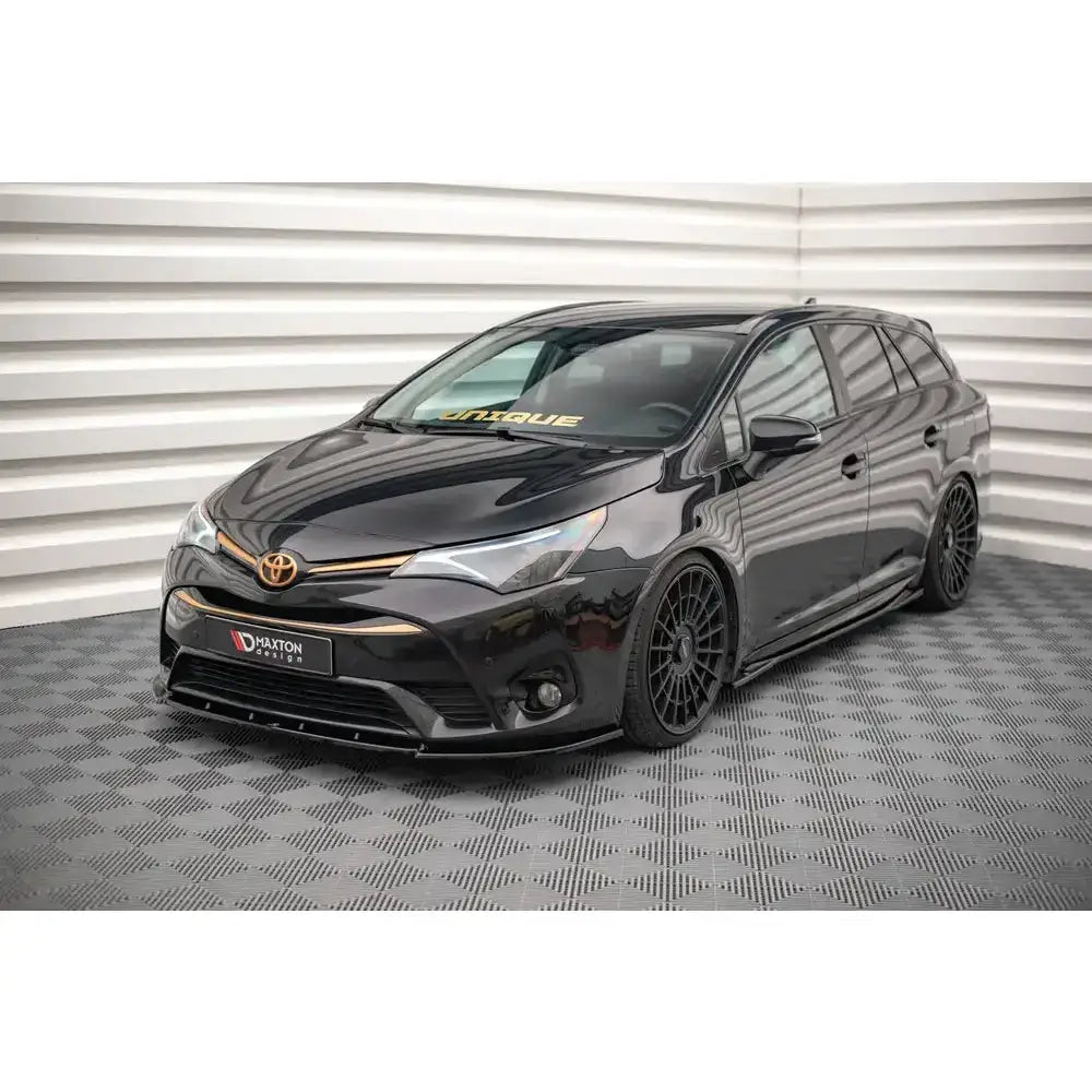 Frontspoiler på Toyota Avensis Mk3 Facelift 15-18 stasjonsvogn med sorte felger og gullfargede detaljer.