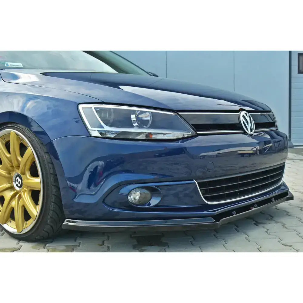 Frontsplitter på Volkswagen Jetta Mk6 Sedan V.1 sett fra venstre med blå lakk og gullfelger.