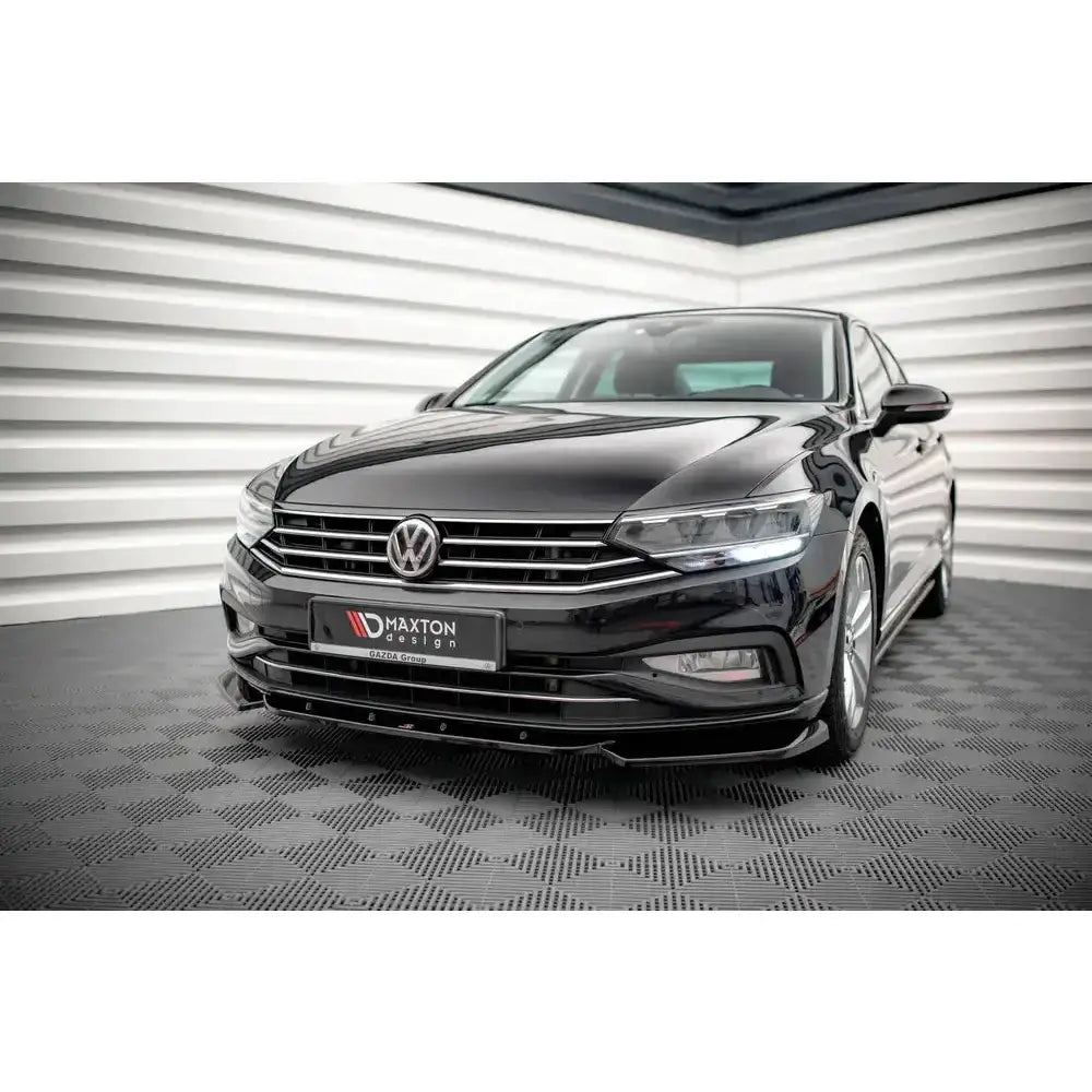 Frontsplitter på Volkswagen Passat B8 Facelift med kromgrill og LED-lykter, sett skrått forfra innendørs.