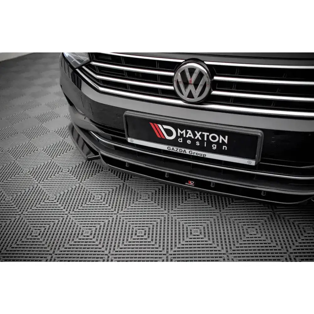 Front lip på Volkswagen Passat B8 Facelift V.1 med kromdetaljer på sort bil, nærbilde av nedre spoiler.