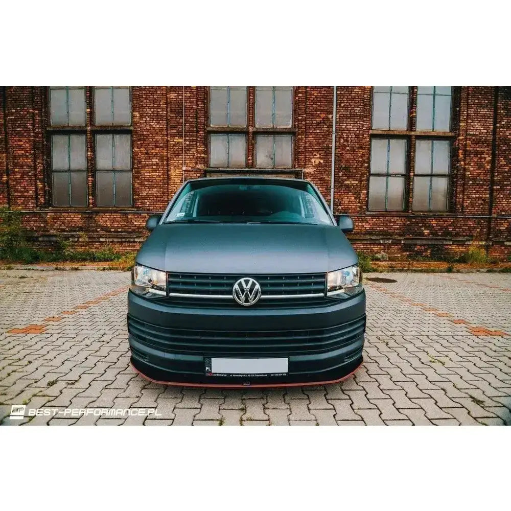 Frontsplitter på Volkswagen T6 V.1, matt svart bil med rød kant foran, parkert på brostein.