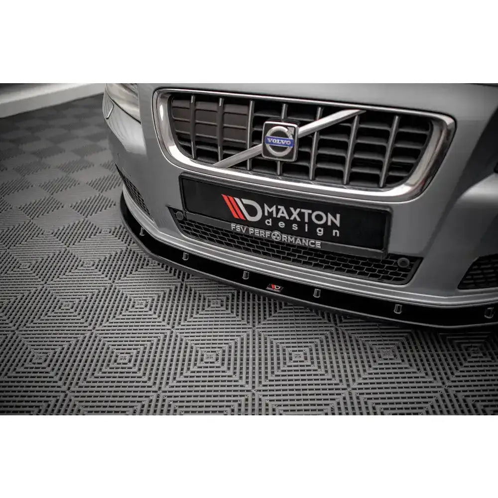Front lip på Volvo V70 Mk3 med sort spoiler montert under grå støtfanger og kromdetaljer.