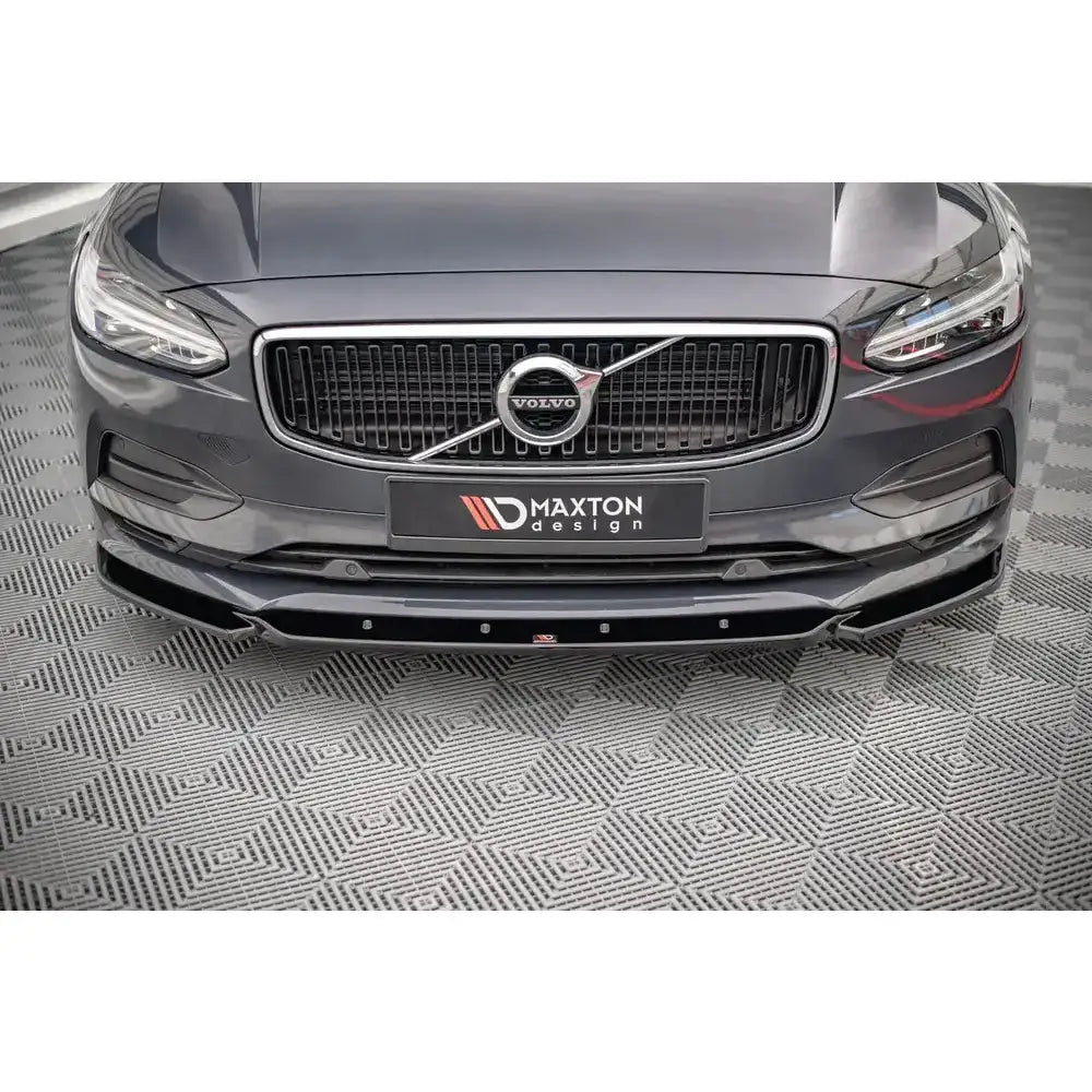 Frontsplitter til Volvo V90 Mk2 16- i sort, sett forfra med synlig grill og Maxton Design-skilt.