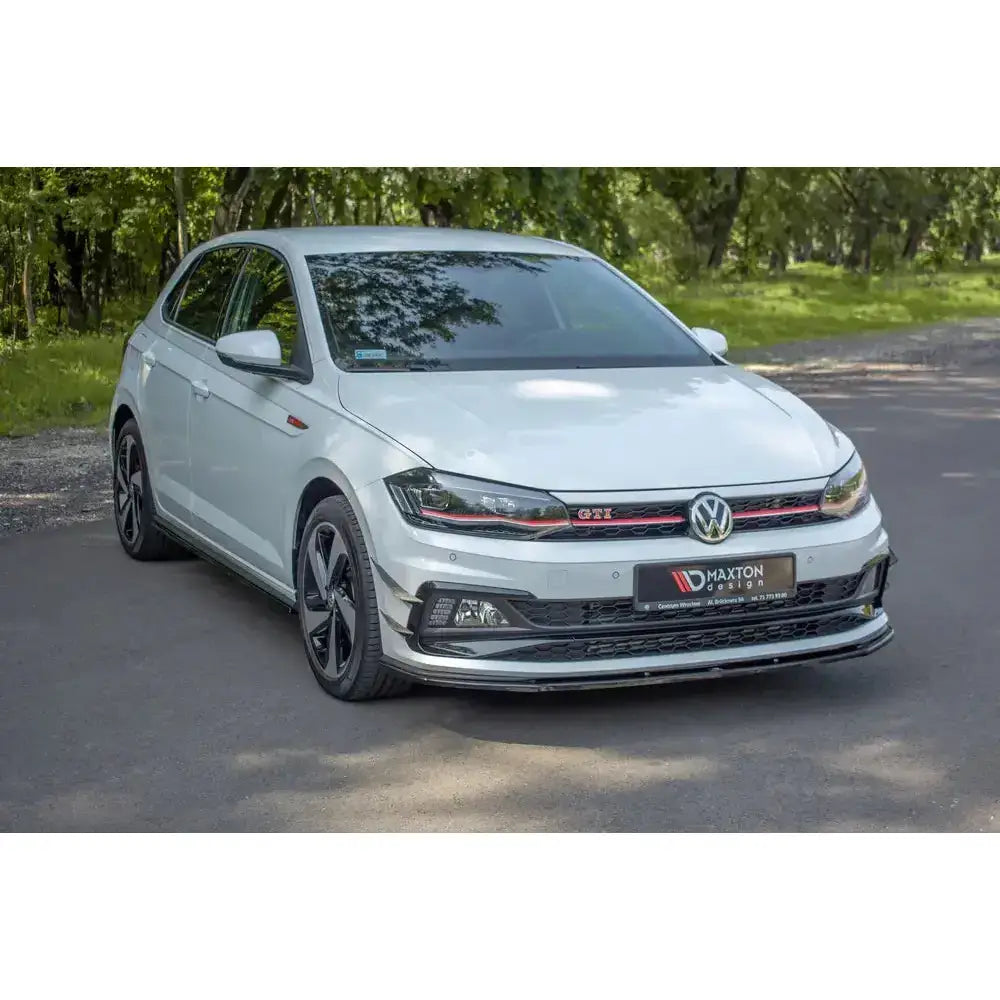 Front lip på hvit VW Polo Mk6 GTI med sorte og røde detaljer, parkert utendørs på asfalt.