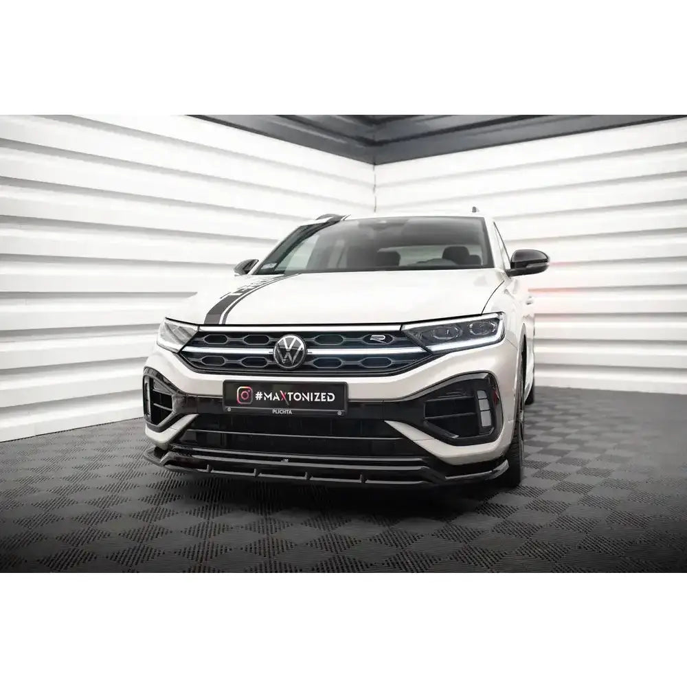 Frontsplitter på VW T-Roc R Mk1 Facelift, hvit bil med sorte detaljer og LED-frontlykter innendørs.