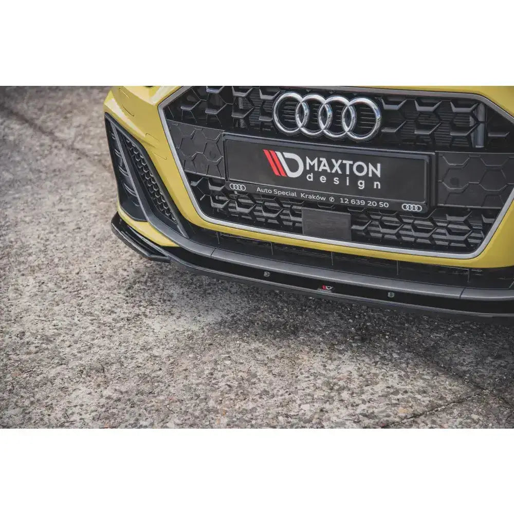 Frontleppe V.2 Audi A1 S-Line GB montert på gul bil med sort grill og Maxton Design-logo på skiltet.