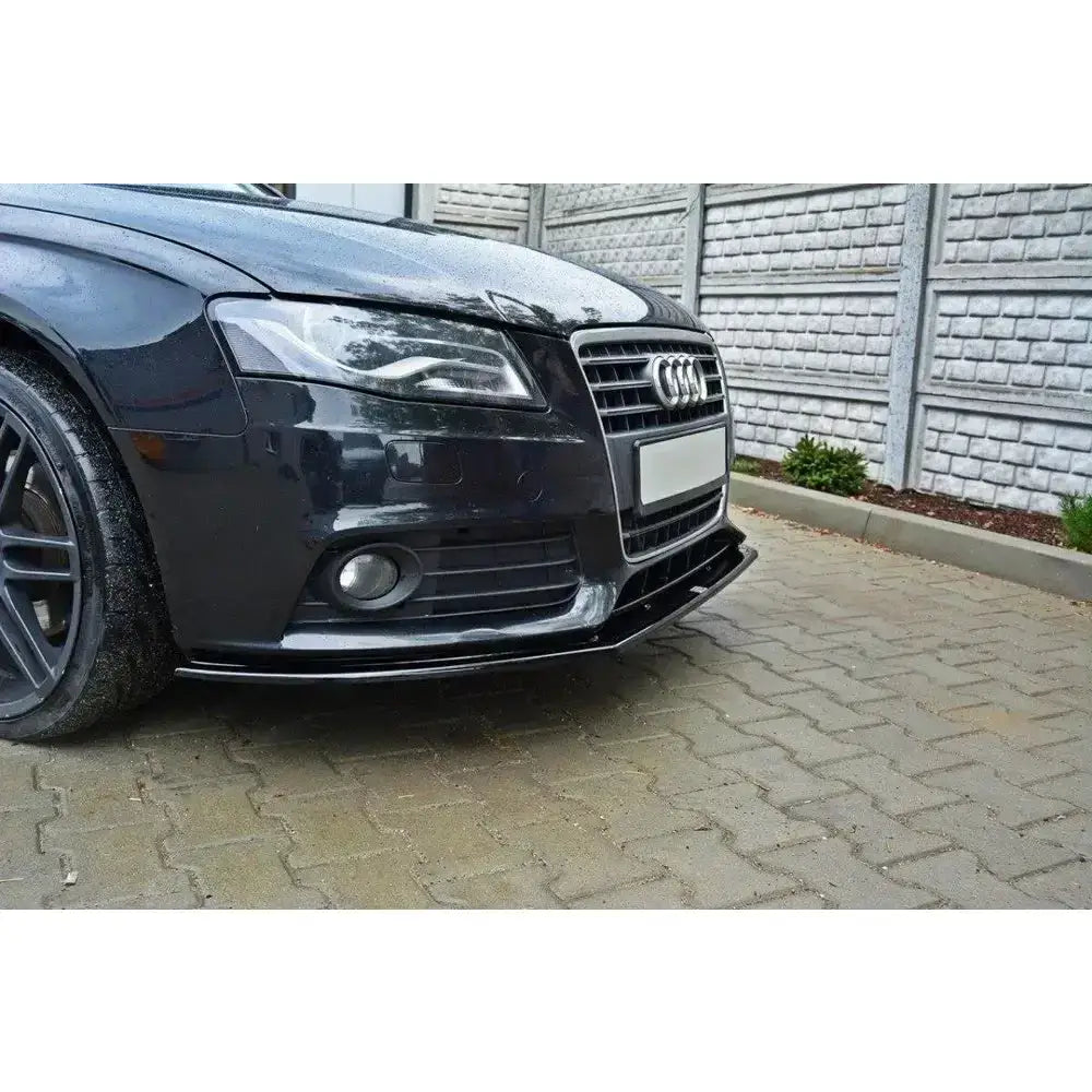 Frontspoiler Audi A4 B8 V.2 i blankt materiale, sett skrått forfra med detaljer av grill og felger.