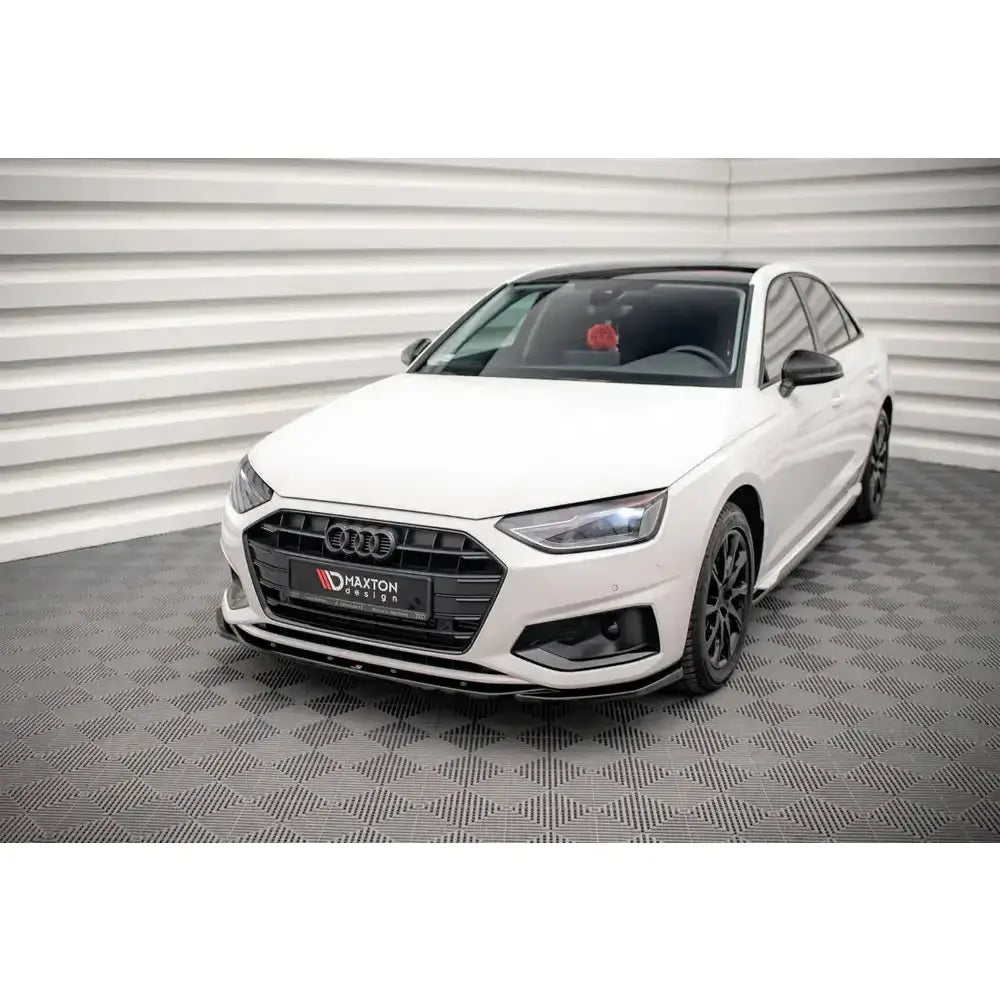 Front lip på hvit Audi A4 B9 Facelift med svarte detaljer, sett skrått forfra i lyst, stripet rom.