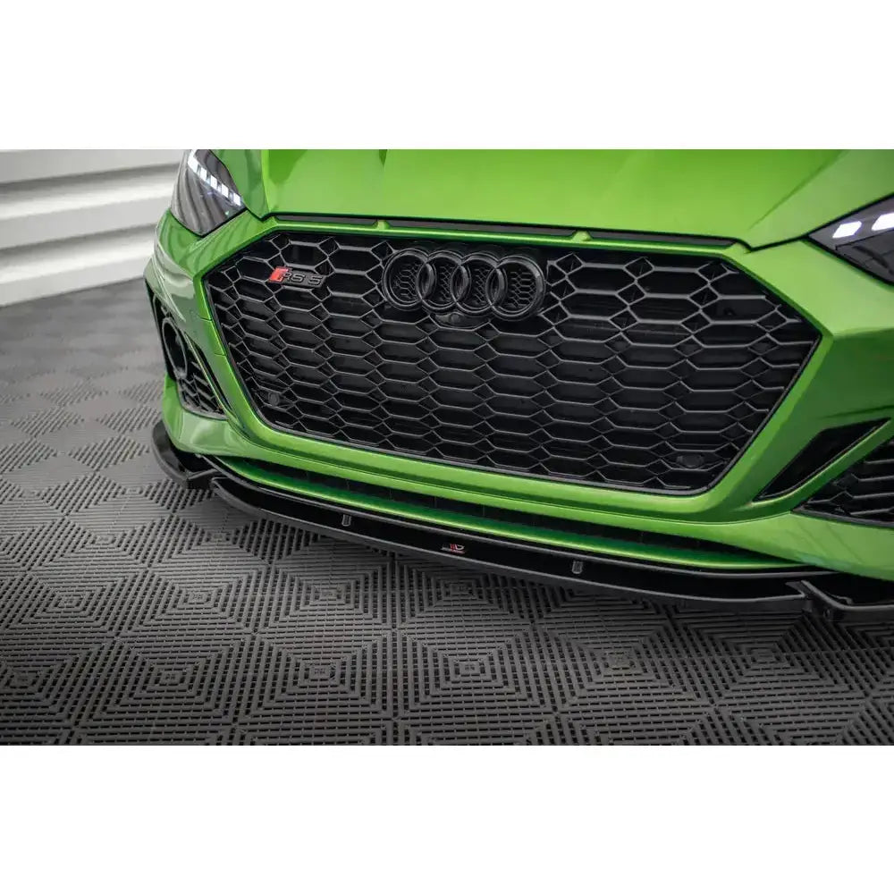Frontsplitter på Audi RS5 F5 Facelift med sort bikubemønstret grill og sort spoiler, nærbilde forfra.