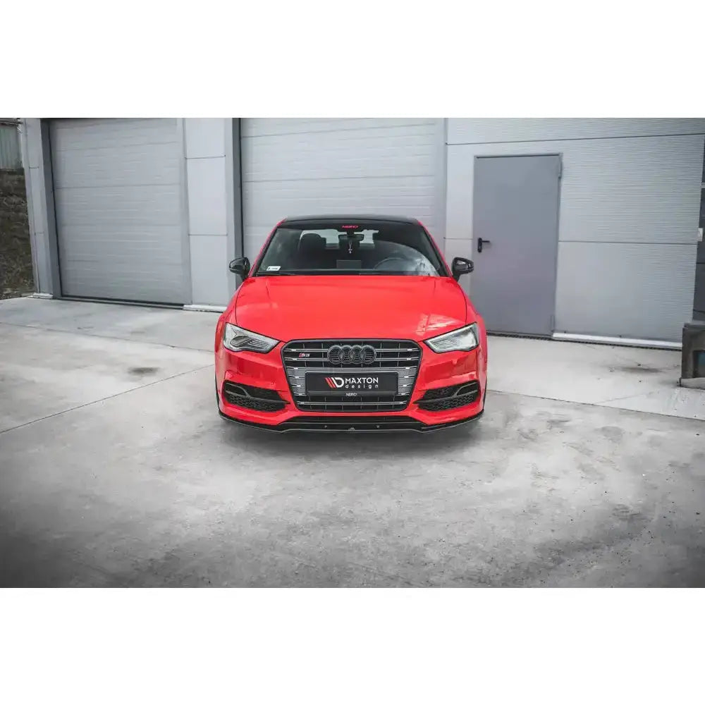 Frontspoiler på Audi S3 med V.2 frontleppe foran grå industribygning, sett rett forfra.