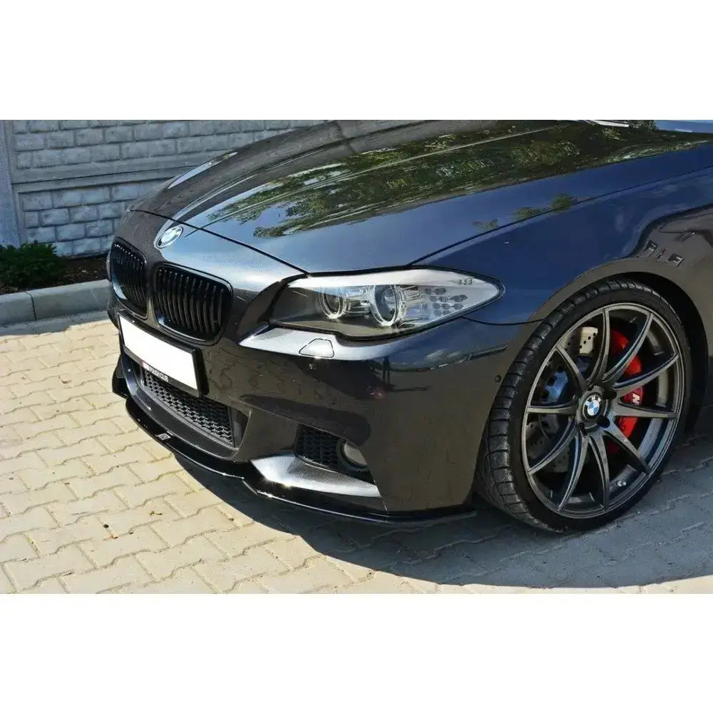 Frontspoiler på BMW 5 F10/F11 Mpack med sorte felger, røde bremsekalipere og sportslig design.