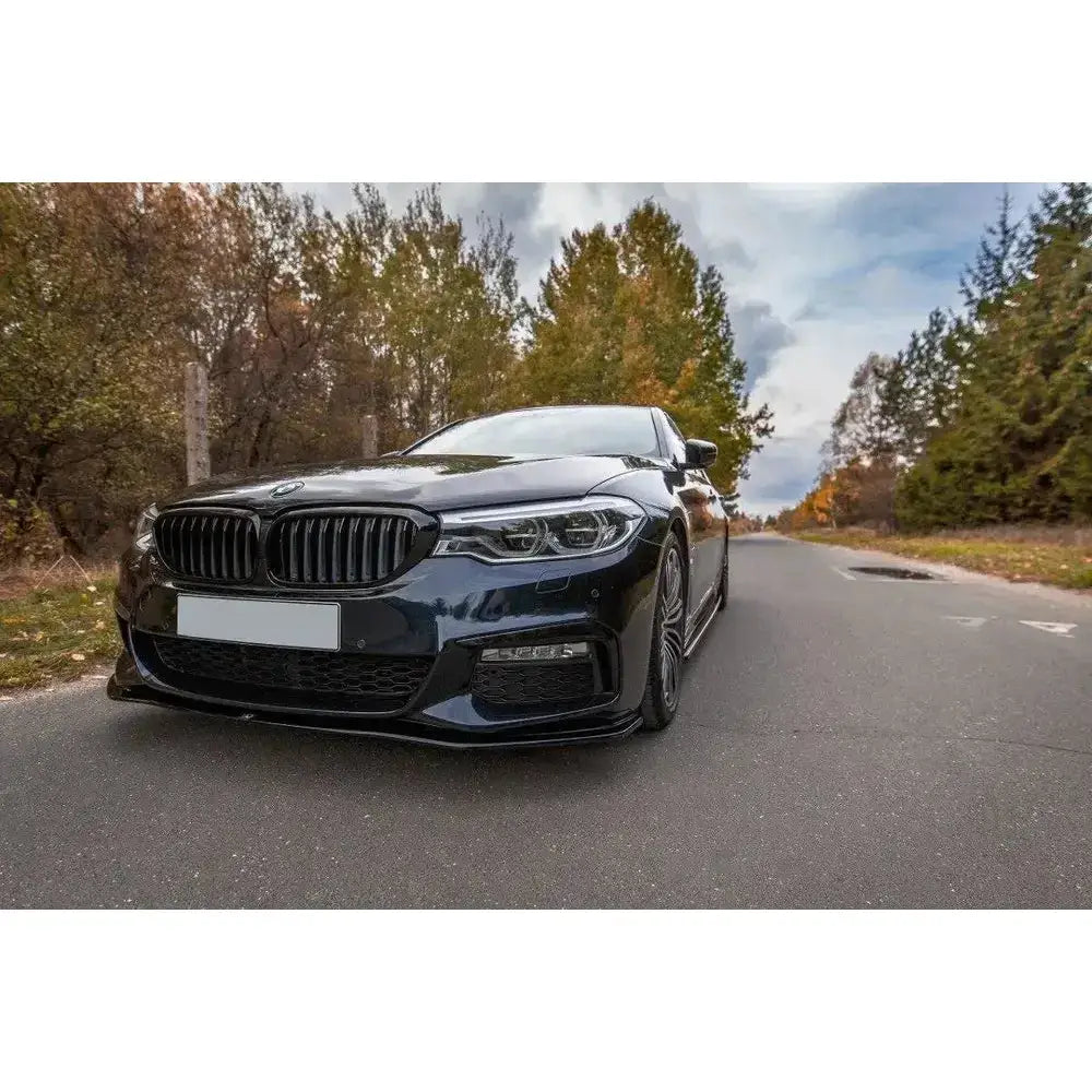 Frontspoiler på BMW 5 G30/G31 M-Pack sett forfra med markante frontlys, grill og høstfarget bakgrunn.