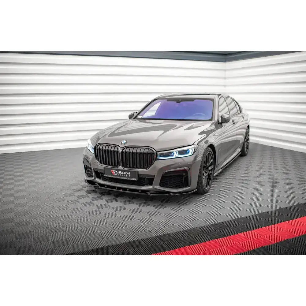 Frontsplitter på BMW 7 G11 M-Pack Facelift med svarte detaljer og markante LED-frontlykter innendørs.