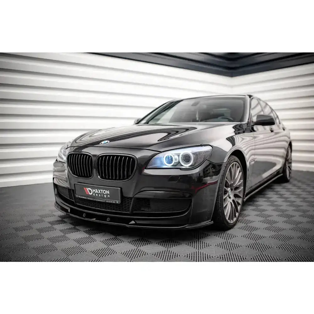 Front lip på BMW 7 M-Pack F01 V.2 med sorte detaljer og blå frontlykter, sett skrått forfra.