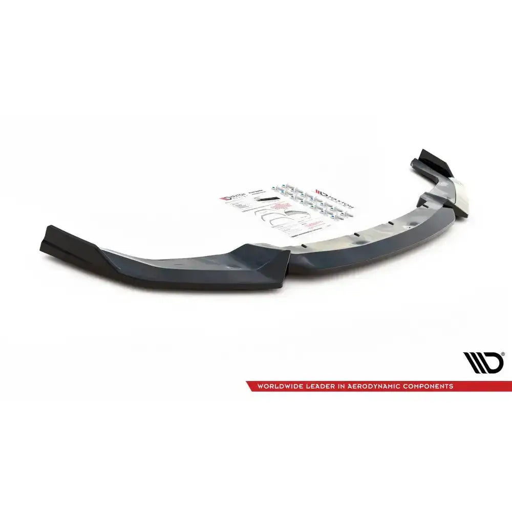 Front splitter til BMW M2 Competition F87 V.2, sort plast med monteringsutstyr og instruksjoner bak.